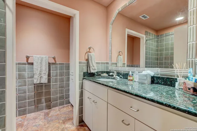 a bathroom with a granite countertop sink and a mirror