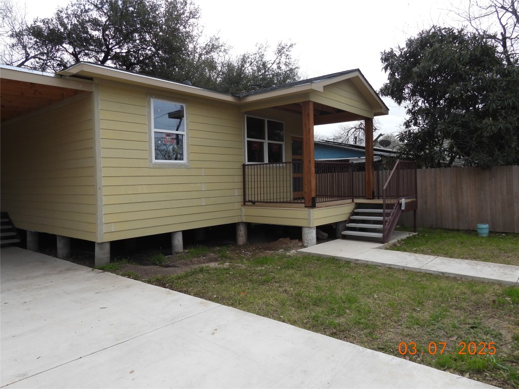 a view of a house with backyard and wooden fence