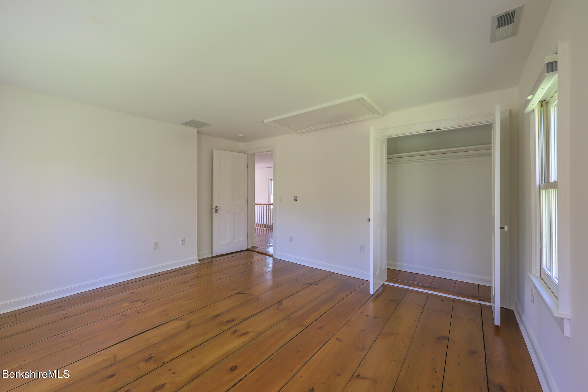 304 Hickey Hill Road Sheffield, MA 01257 - Photo 35 of 60 an empty room with wooden floor and windows