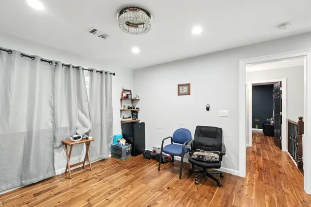 a view of a workspace with furniture and wooden floor