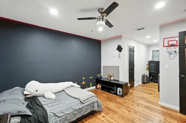 a bedroom with a bed and wooden floor
