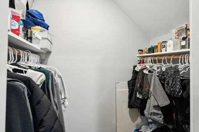 a view of walk in closet with clothes and shoes