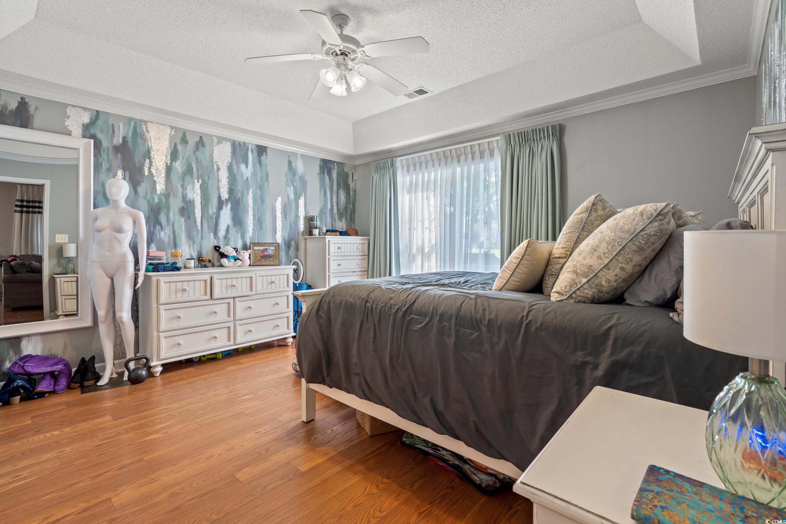 509 Shellbank Drive, Unit B Longs, SC 29568 - Photo 12 of 33 Bedroom featuring a raised ceiling, light wood finished floors, a textured ceiling, ornamental molding, and a ceiling fan