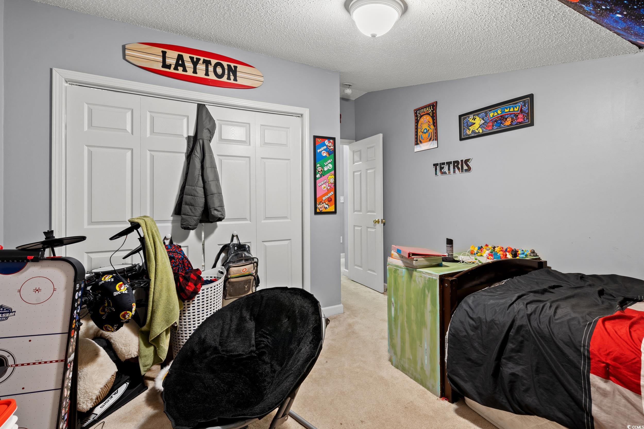 509 Shellbank Drive, Unit B Longs, SC 29568 - Photo 23 of 33 Bedroom featuring carpet, a closet, and a textured ceiling
