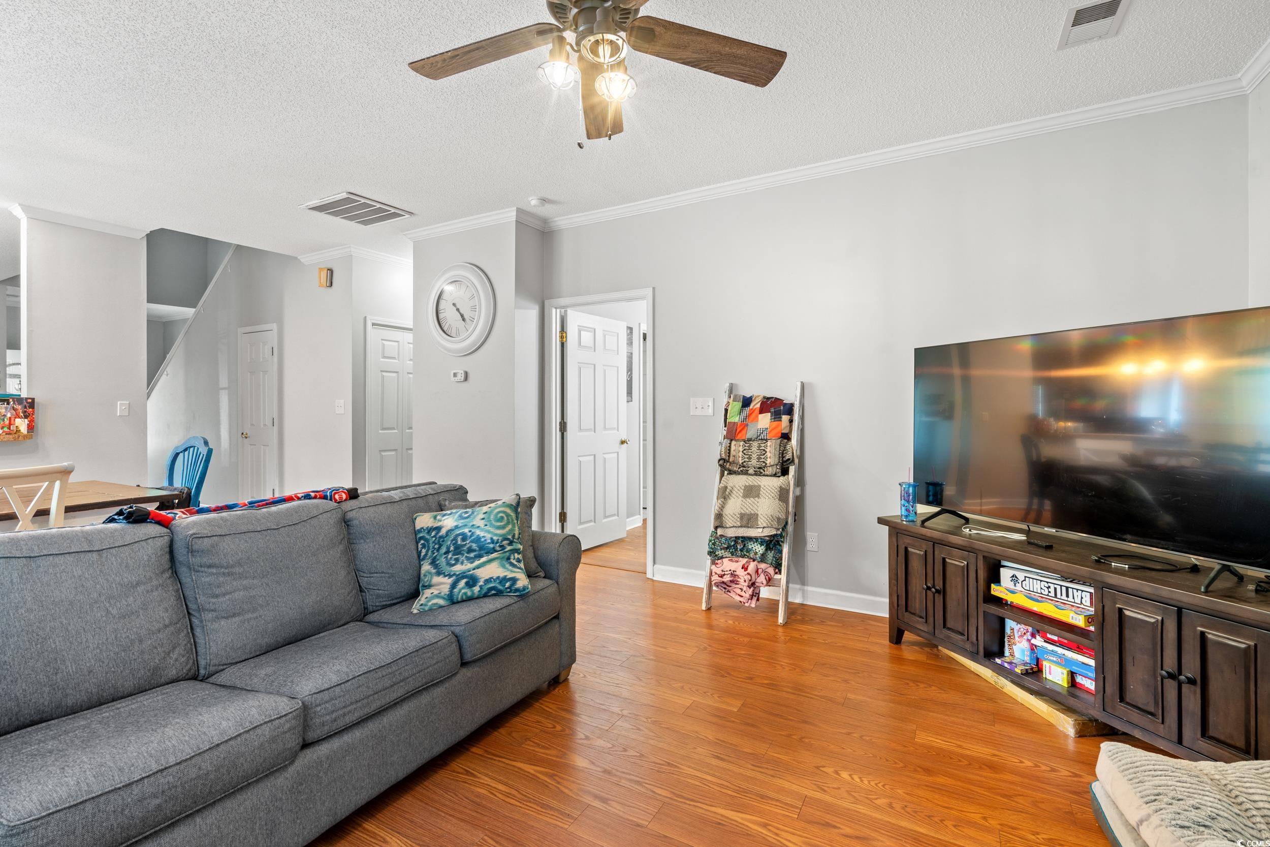 509 Shellbank Drive, Unit B Longs, SC 29568 - Photo 6 of 33 Living area with light wood finished floors, a ceiling fan, crown molding, and a textured ceiling