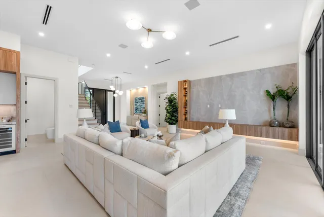 a dining room with furniture large windows and a chandelier