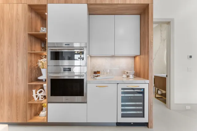 a large kitchen with stainless steel appliances a large counter top a stove and a refrigerator