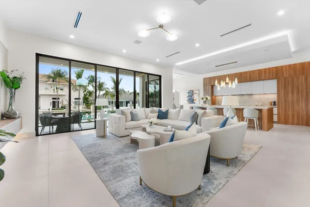 a dining room with furniture a chandelier and a large window
