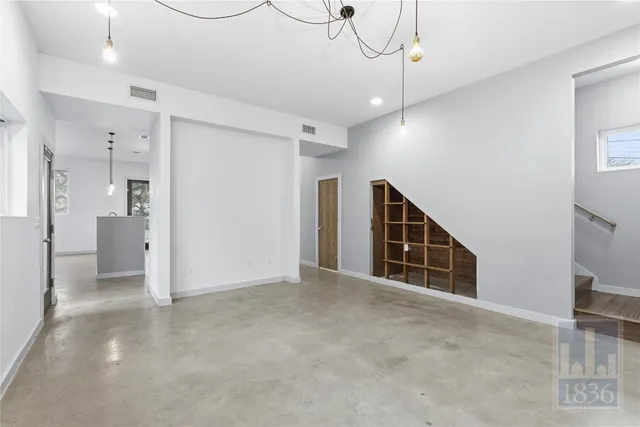 a view of an empty room with closet and a window