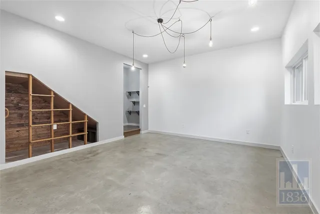 an empty room with windows and ceiling fan