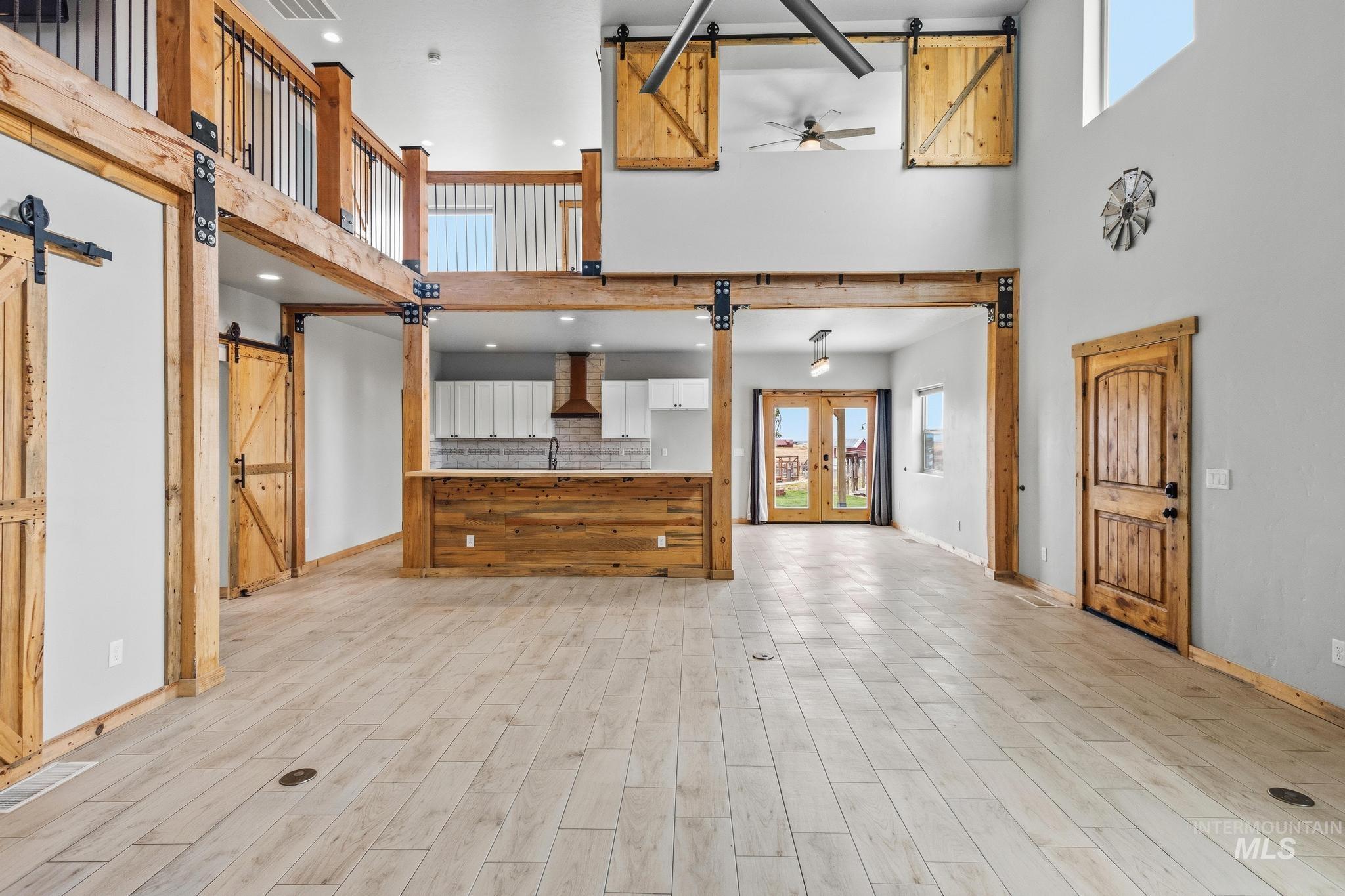870 Desert Wind Road Boise, ID 83716 - Photo 14 of 50 Open-concept interior featuring wood-finish flooring, exposed wood beams, and a vaulted ceiling
