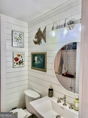a bathroom with a sink mirror and toilet