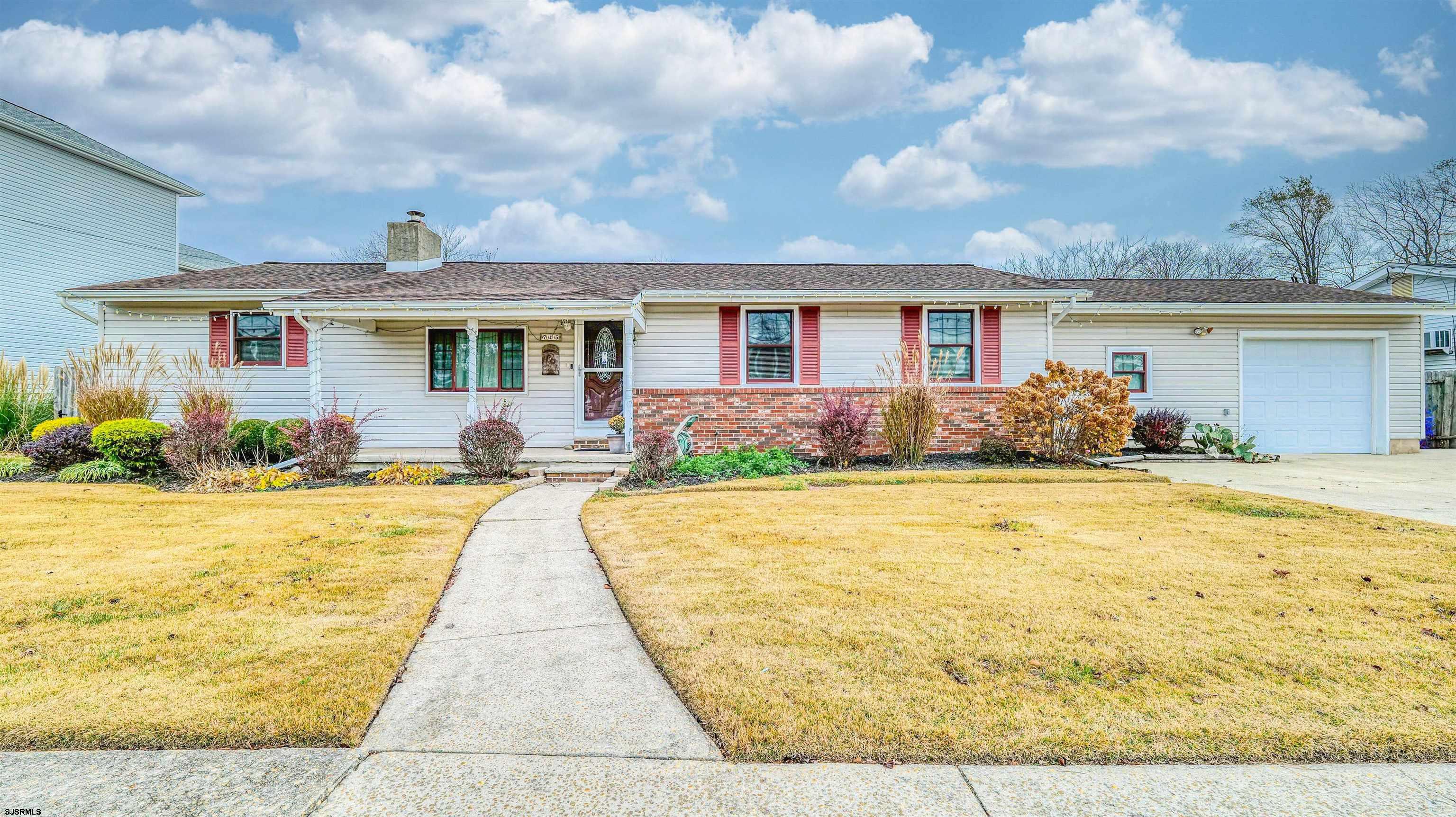 a front view of house with yard and outdoor seating