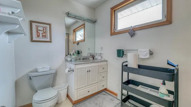 a bathroom with a toilet a sink a vanity and mirror