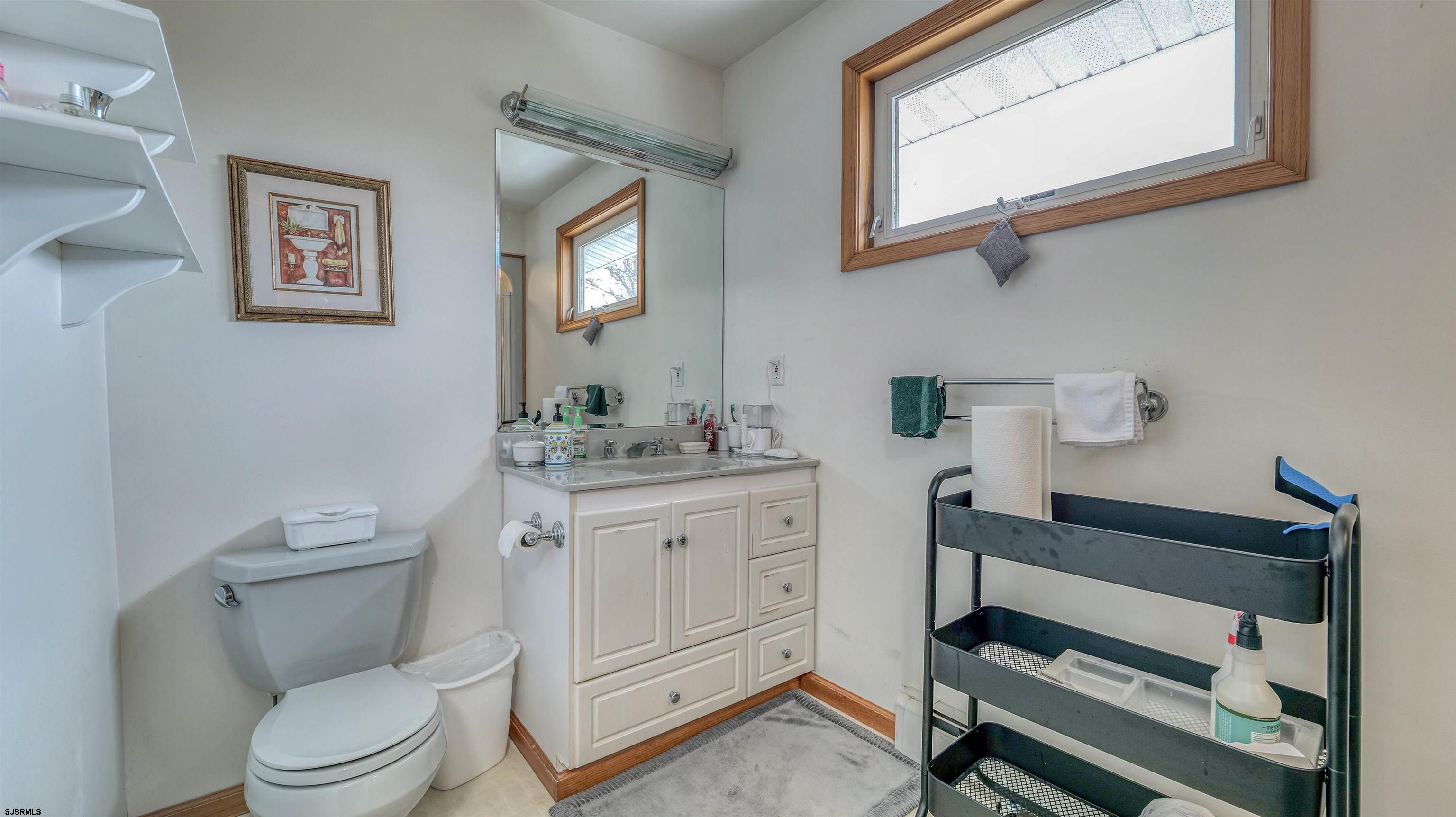 715 Lafayette Boulevard Brigantine, NJ 08203 - Photo 20 of 31 a bathroom with a toilet a sink a vanity and mirror