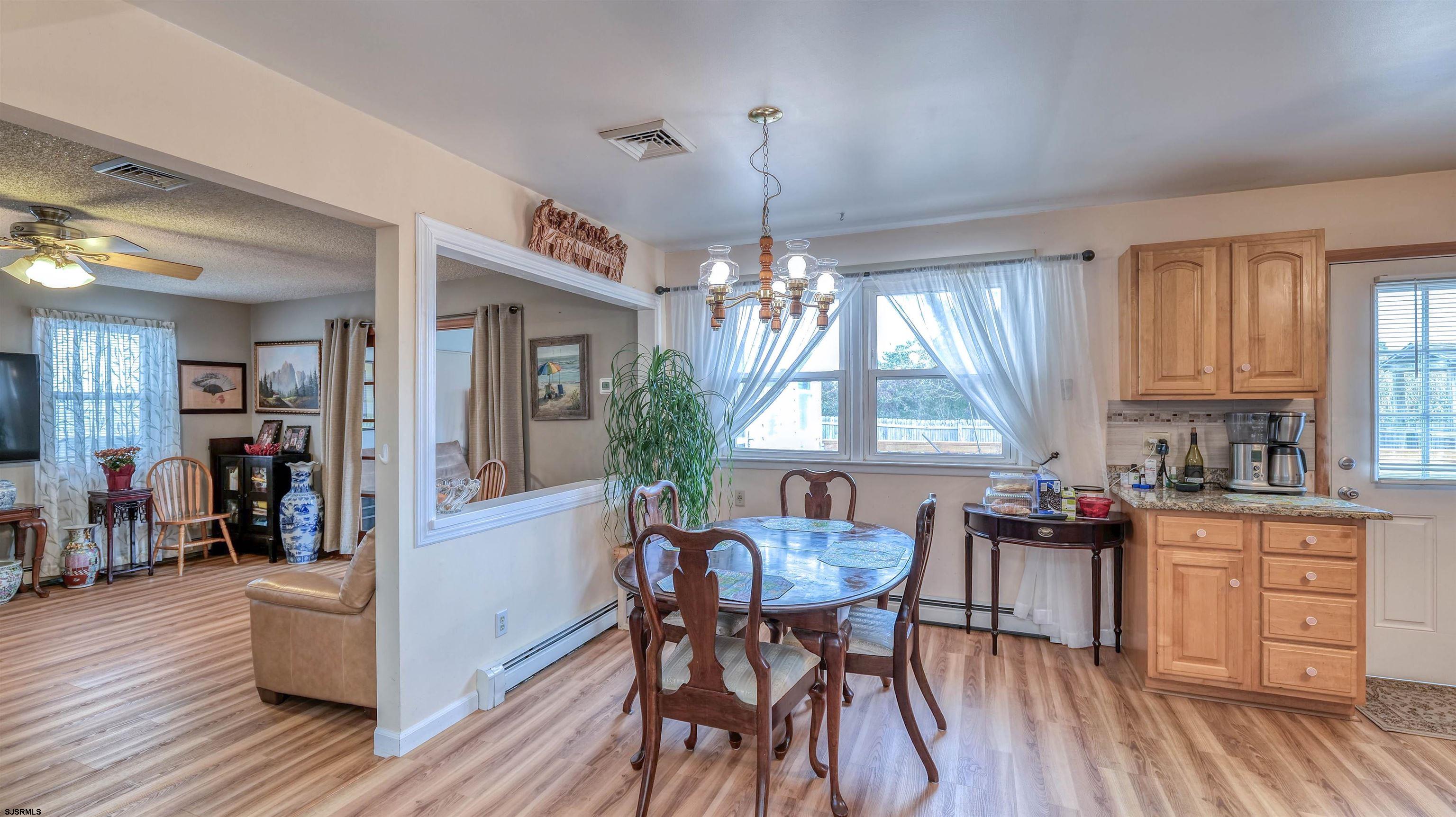 715 Lafayette Boulevard Brigantine, NJ 08203 - Photo 6 of 31 a kitchen with a table chairs and wooden floor