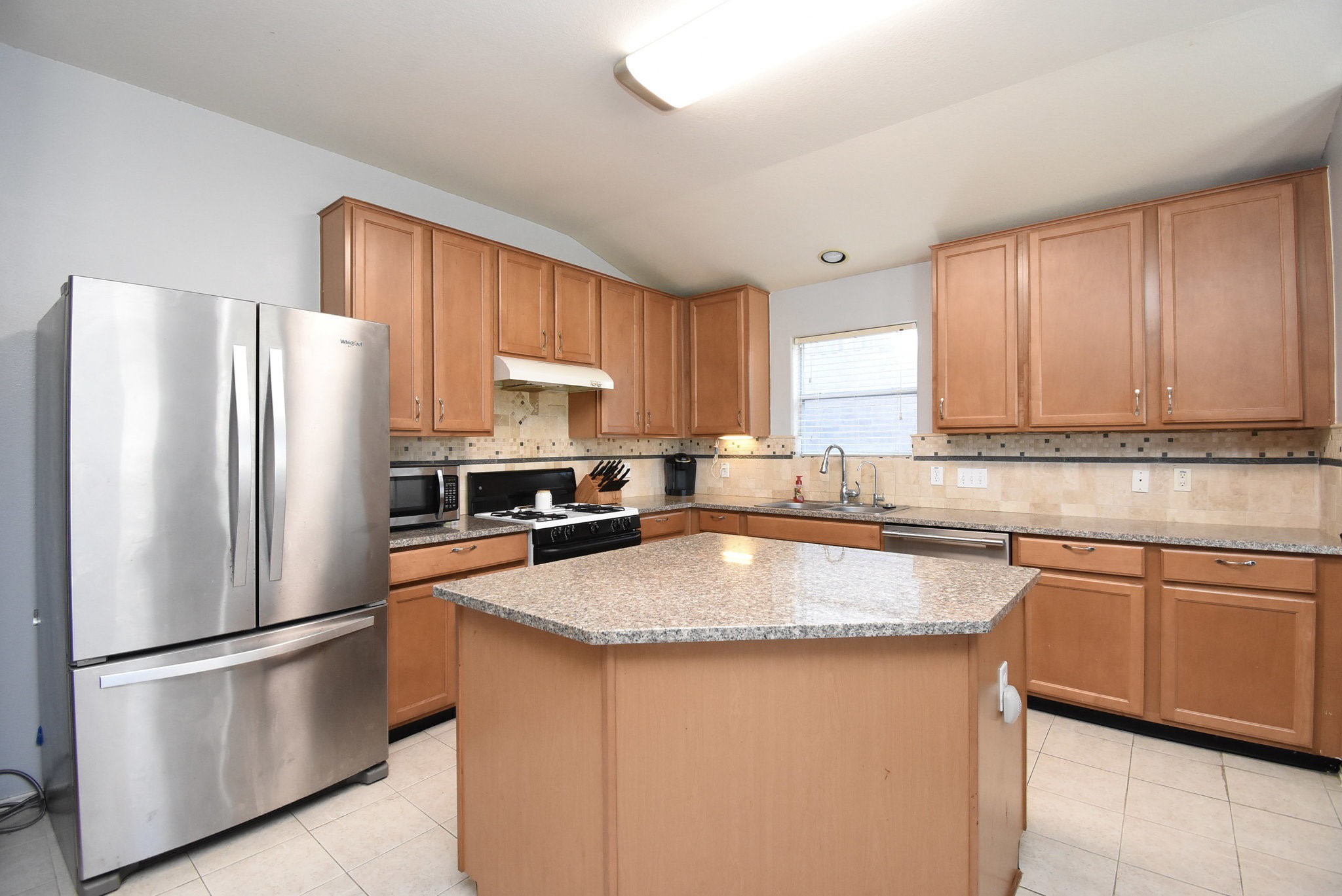 8502 Parapet Place Rosharon, TX 77583 - Photo 12 of 34 a kitchen with stainless steel appliances granite countertop a refrigerator a sink a stove a microwave and wooden cabinets