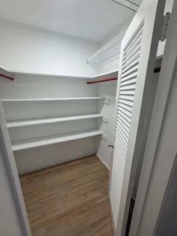 a view of walk in closet with empty racks