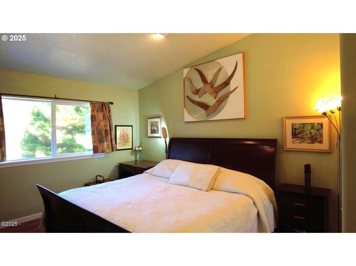 3512 Highway 101 Yachats, OR 97498 - Photo 22 of 39 a bedroom with a bed and a painting on the wall