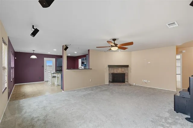 a view of a livingroom with a ceiling fan fireplace and window