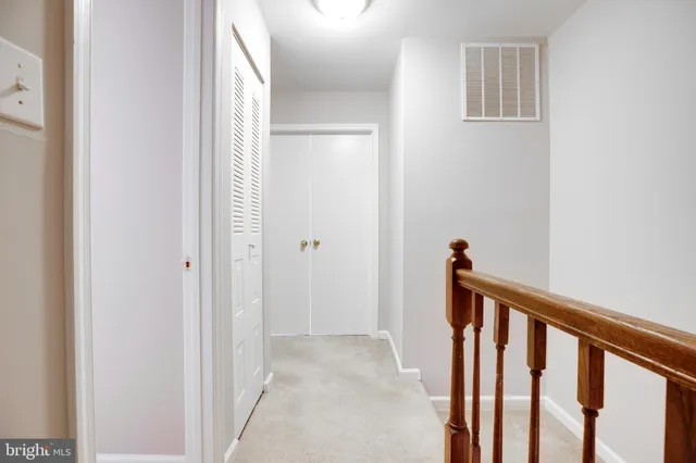 a view of a hallway with a white door and stairs