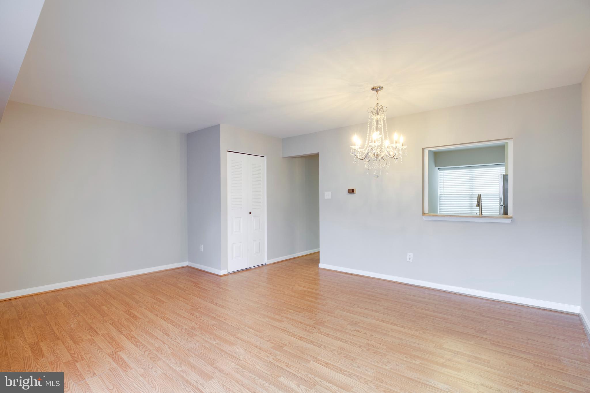 241 Coventry Square Sterling, VA 20164 - Photo 5 of 29 a view of an empty room with wooden floor and a chandelier