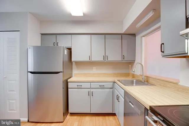 a kitchen with a sink a refrigerator and cabinets