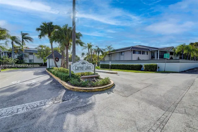 a front view of a house with a yard and potted plants