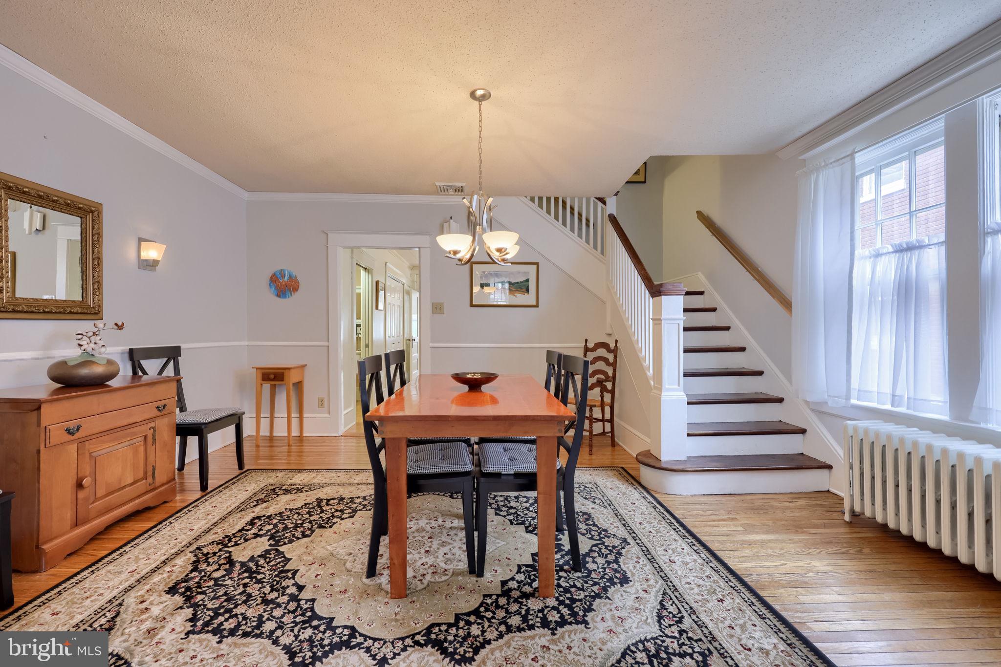 1013 Locust Street Columbia, PA 17512 - Photo 18 of 47 a dining room with wooden floor a chandelier a wooden table and chairs