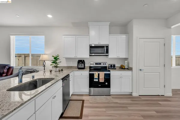 a kitchen with white cabinets sink and stainless steel appliances