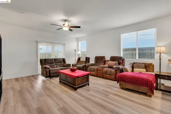 a kitchen with stainless steel appliances granite countertop a refrigerator a stove a sink a dining table and chairs with wooden floor
