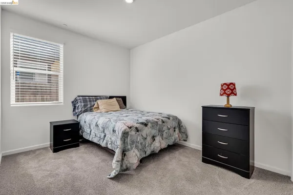 a bedroom with a bed and a lamp on table