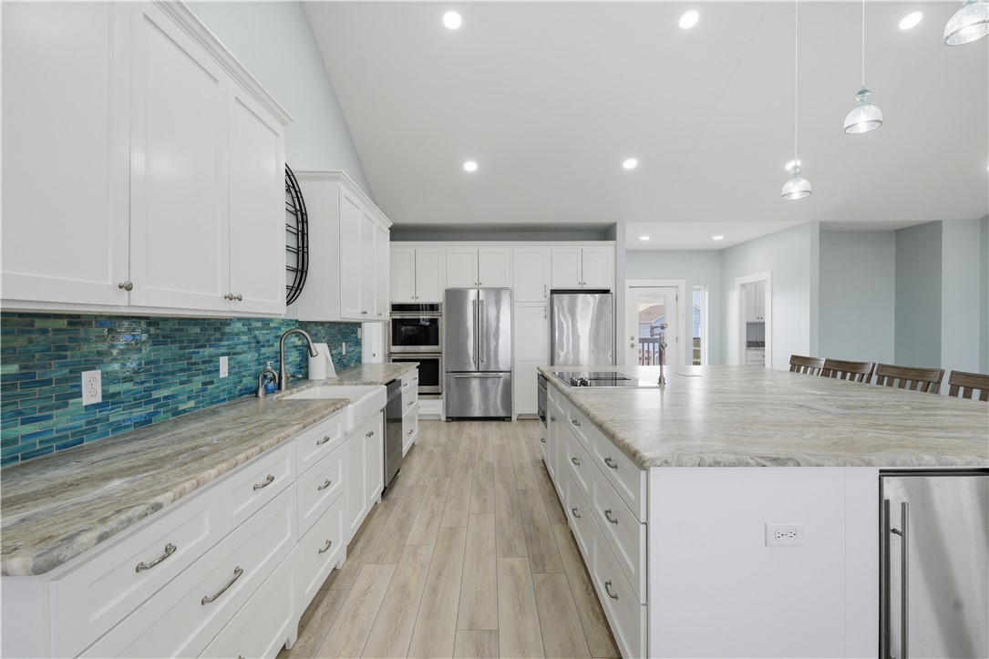 142-143 Channelview Road Rockport, TX 78382 - Photo 11 of 40 a large kitchen with granite countertop a large counter top and stainless steel appliances