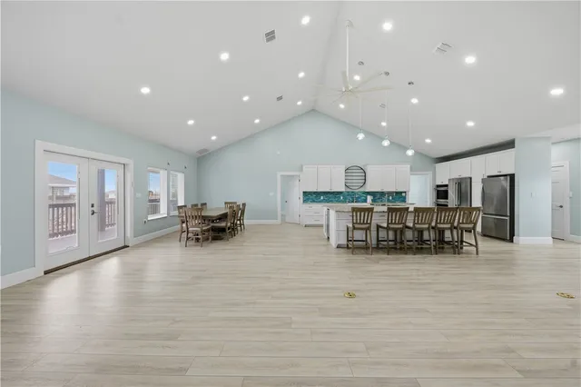 a room with stainless steel appliances wooden floor and large windows