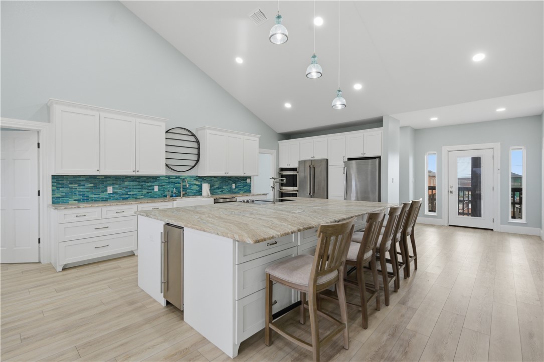 142-143 Channelview Road Rockport, TX 78382 - Photo 15 of 40 a kitchen with stainless steel appliances kitchen island granite countertop a table chairs sink and cabinets