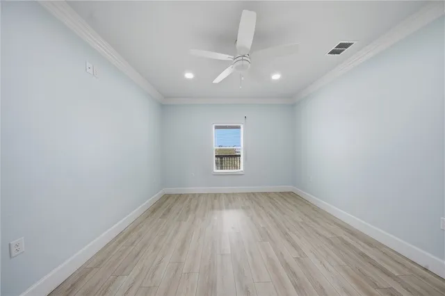 a view of a hallway with wooden floor and a bathroom
