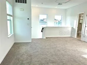 an empty room with windows and cabinet