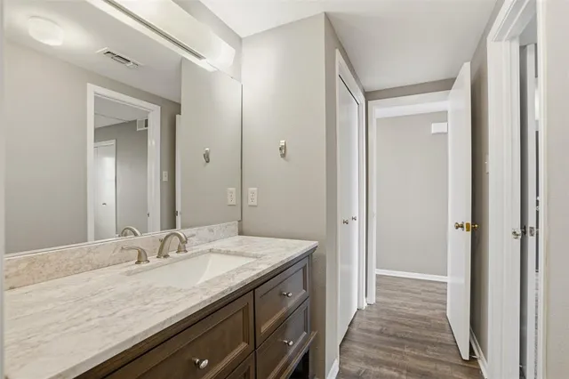 a bathroom with a granite countertop sink and a mirror