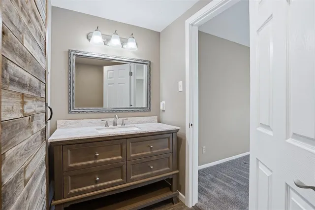 a bathroom with a granite countertop sink a mirror and a vanity