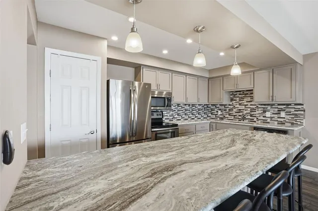 a kitchen with stainless steel appliances granite countertop a sink refrigerator and cabinets