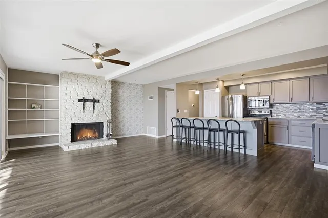 a view of a living room a fireplace with windows and wooden floor