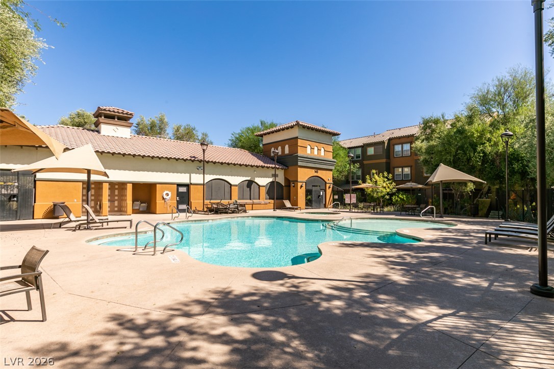 4650 Ranch House Road, Unit 46 North Las Vegas, NV 89031 - Photo 38 of 38 A sparkling community pool is surrounded by spacious lounging areas under clear blue skies.