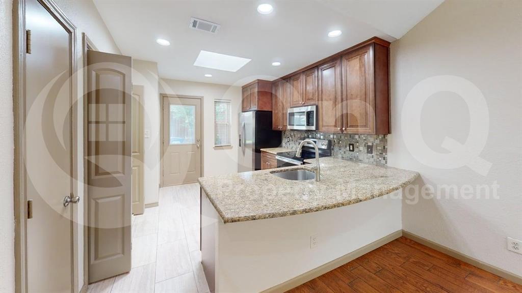 3000 Timothy Lane Euless, TX 76039 - Photo 3 of 19 Kitchen featuring granite countertops, wood cabinetry, stainless steel appliances, and a mosaic tile backsplash