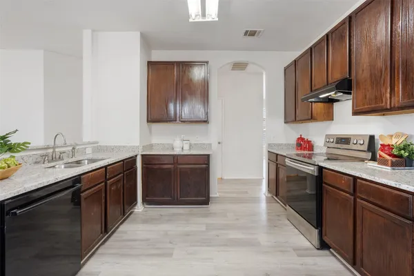 a kitchen with stainless steel appliances granite countertop a sink stove and cabinets