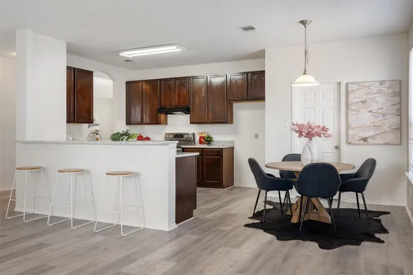 a kitchen with a table chairs refrigerator and cabinets