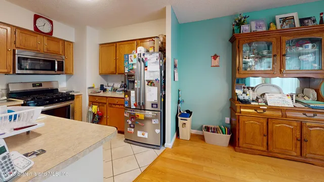 a kitchen with stainless steel appliances kitchen island granite countertop a refrigerator and a stove top oven
