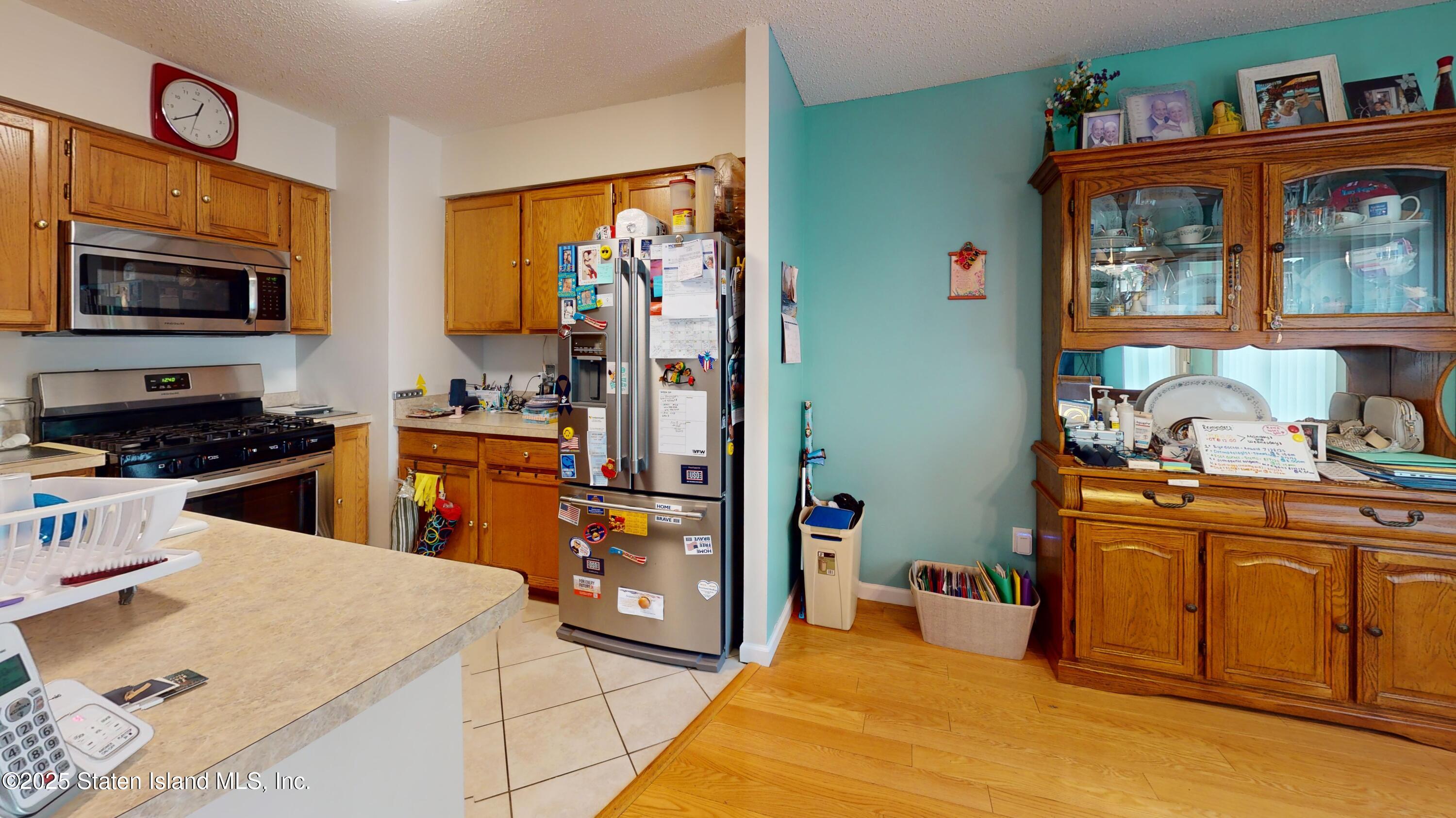 235 Ilyssa Way Staten Island, NY 10312 - Photo 7 of 30 a kitchen with stainless steel appliances kitchen island granite countertop a refrigerator and a stove top oven