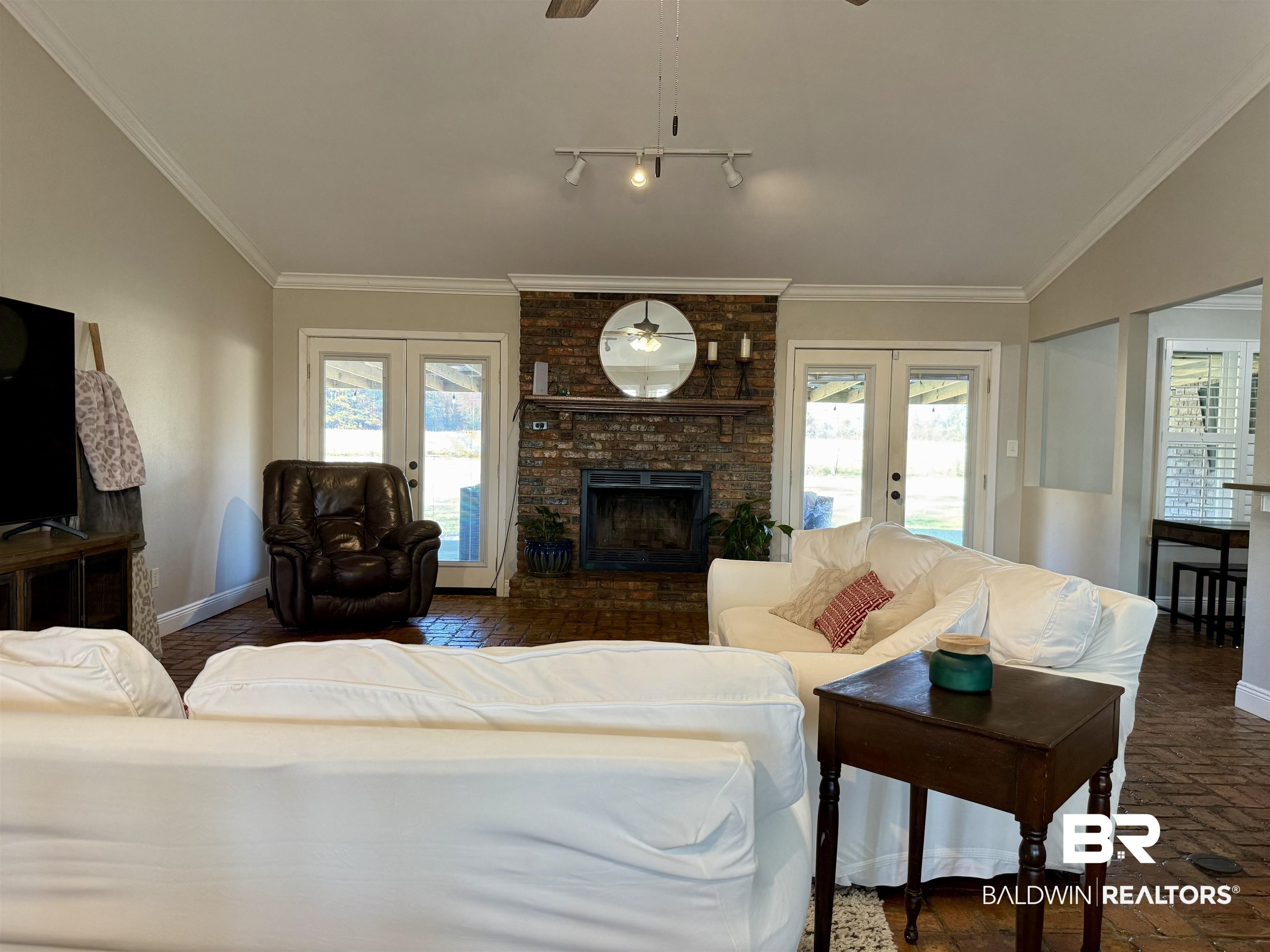 5646 Foshee Road Brewton, AL 36426 - Photo 4 of 37 Living area with french doors, a ceiling fan, a fireplace, brick flooring, and track lighting
