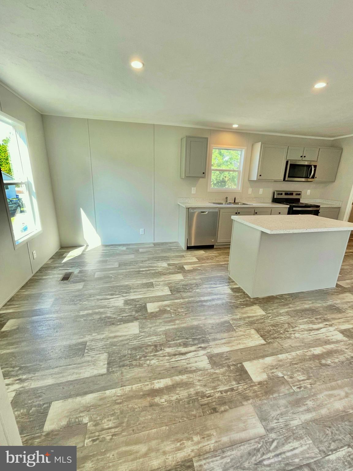 86 Cherokee Avenue Dover, PA 17315 - Photo 16 of 38 a view of a kitchen with kitchen island a sink wooden floor and a living room view