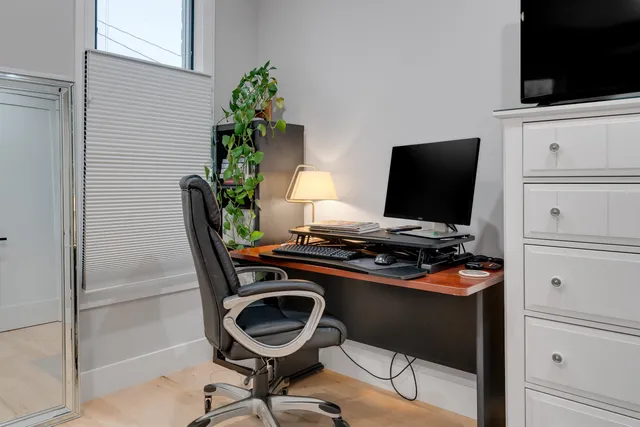a view of a workspace with furniture and a flat screen tv